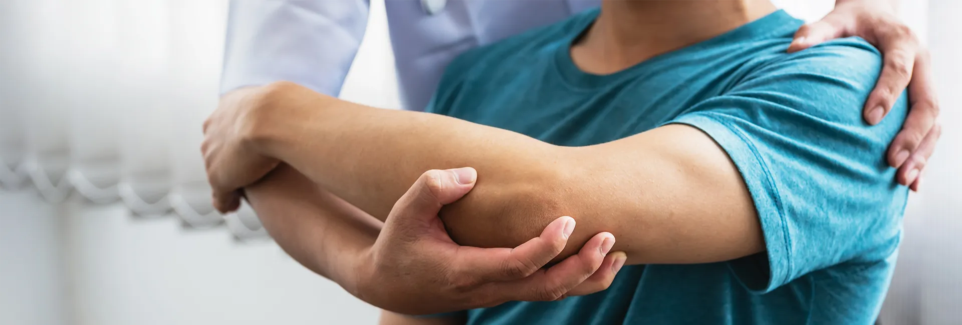 Arbeiten im Reha-Zentrum Bad Aussee: Physiotherapeut behandelt Patientenarm